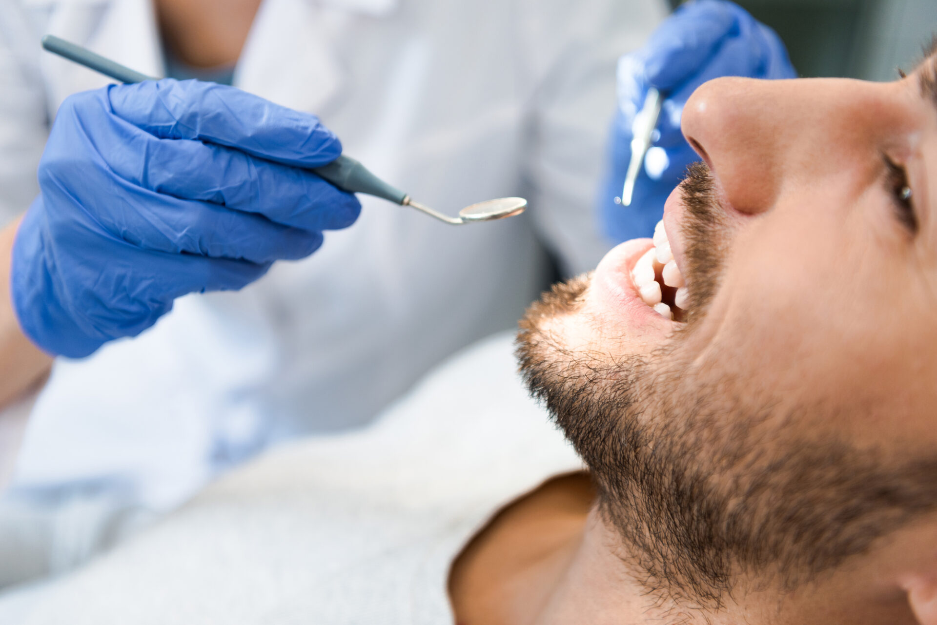 man getting teeth examined by dentist